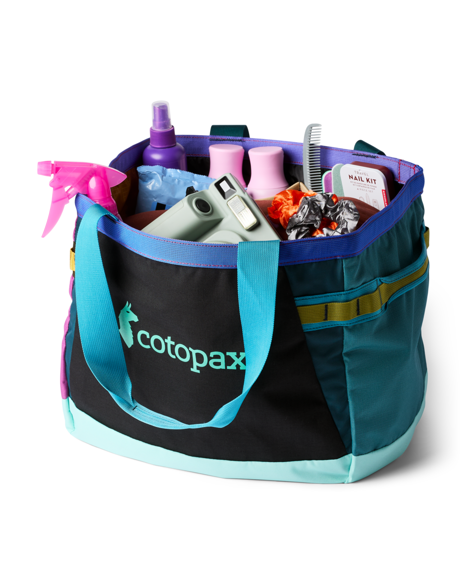 Large tote bag with colorful panels filled with travel and grooming items