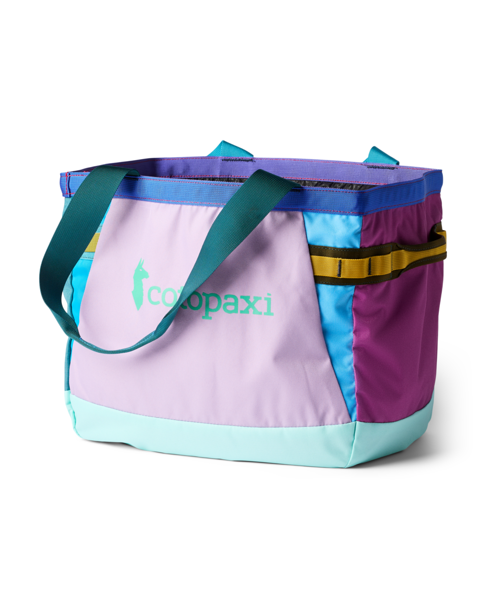 Colorful patchwork tote bag with multiple fabric panels and teal handles on white background