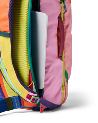 Multicolored travel backpack with laptop compartment open, showing vibrant patchwork design