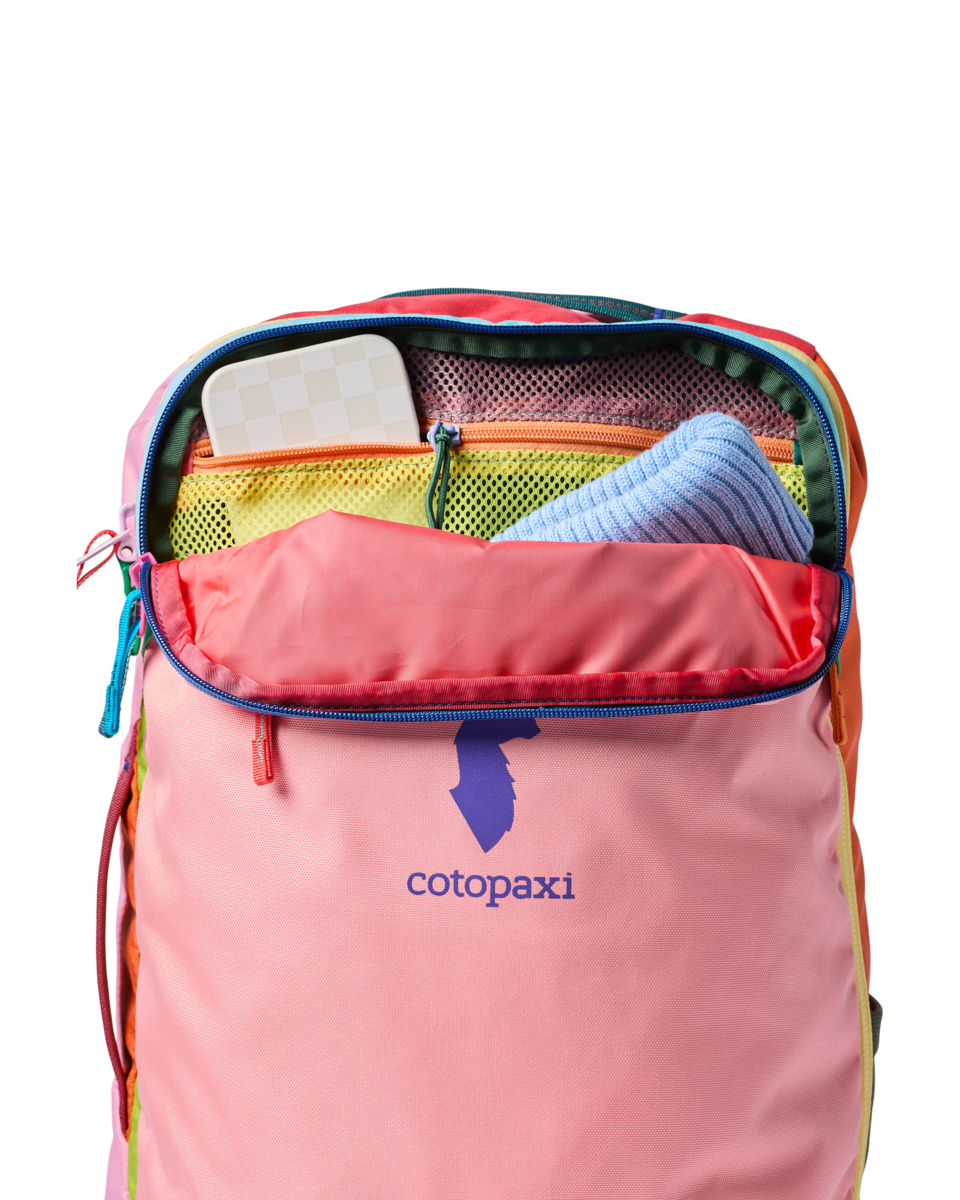 Multicolored travel backpack with main compartment open showing interior organization pockets and mesh compartments