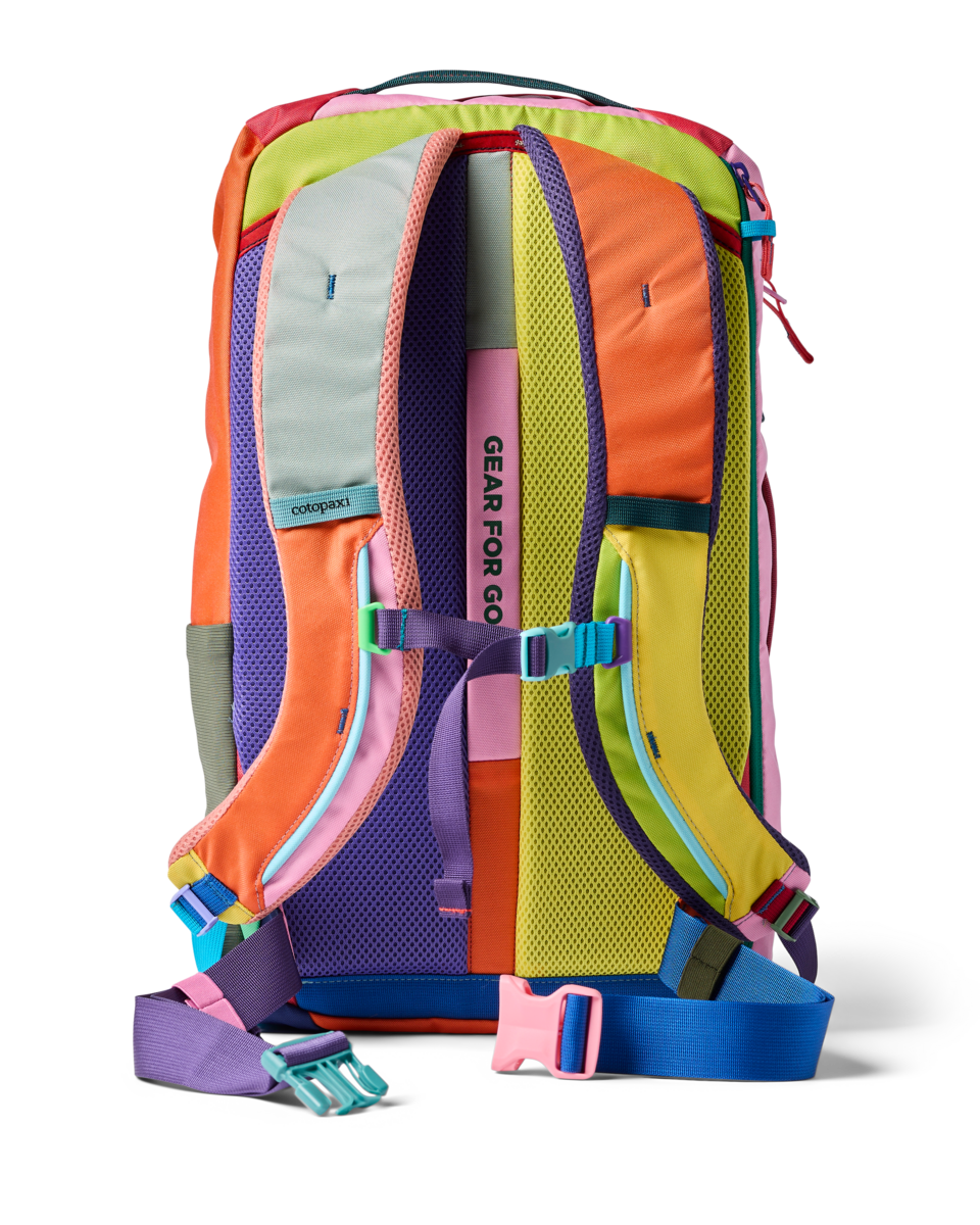 Multicolored patchwork travel backpack shown from back view with shoulder straps and chest strap visible