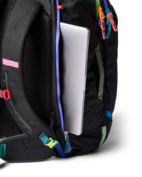 Black travel backpack with laptop compartment open showing colorful accent straps and zippers