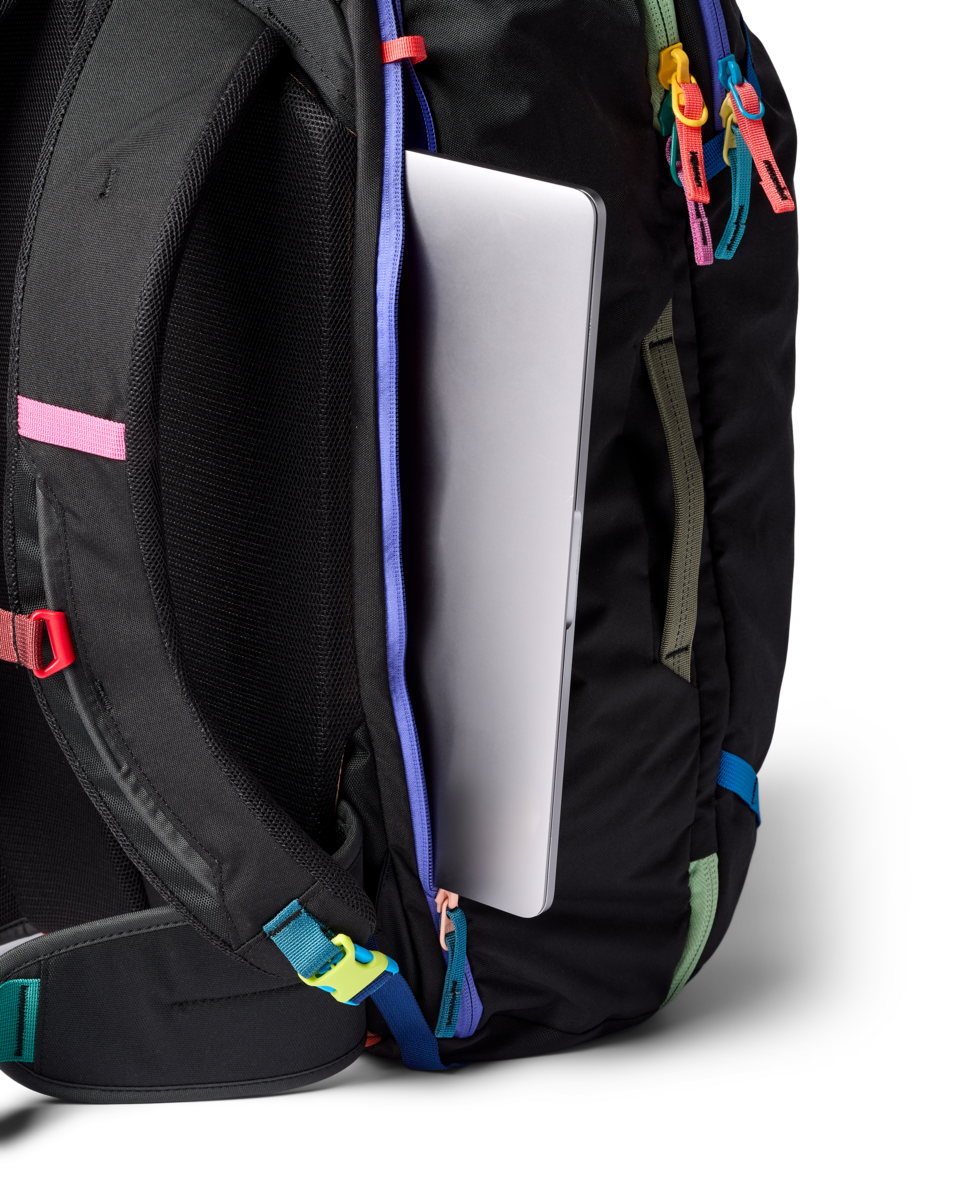 Black travel backpack with laptop compartment open showing colorful accent straps and zippers