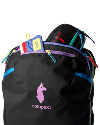 Black travel backpack with colorful zipper accents and top loading compartment open showing contents