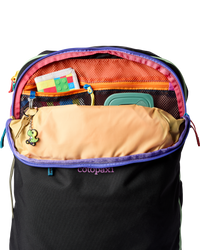 Black travel backpack open showing colorful rainbow interior compartments and organization pockets