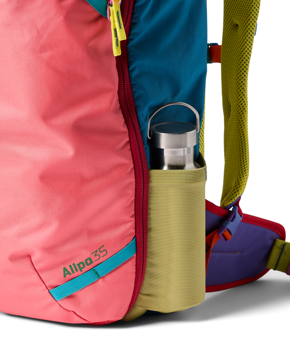 Colorful travel backpack with multicolor panels and side water bottle pocket detail