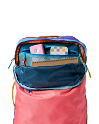 Multicolored travel backpack with main compartment open showing organized interior pockets and storage
