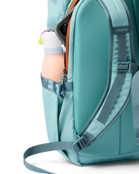 Teal daypack side view showing water bottle pocket, shoulder straps, and open main compartment