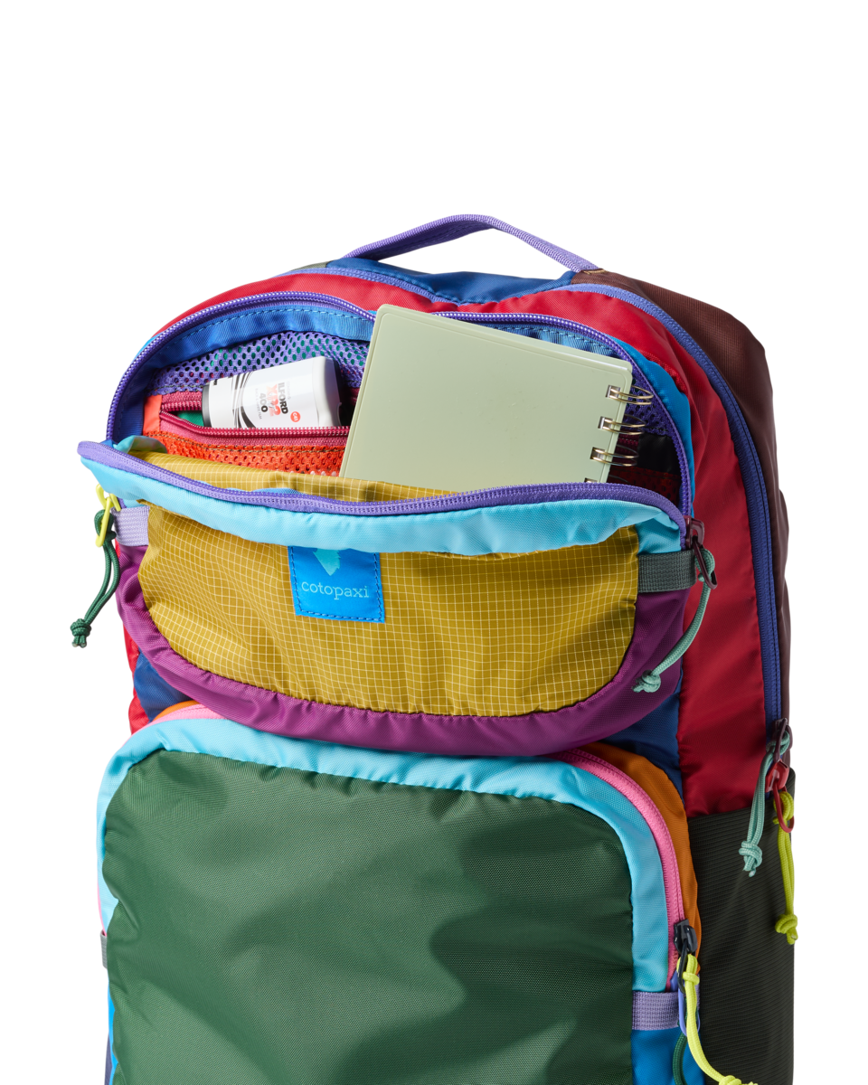 Multicolored patchwork backpack with multiple compartments open showing interior organization and storage