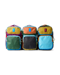 Three colorful backpacks with mixed fabric panels in bright colors, front view on white background