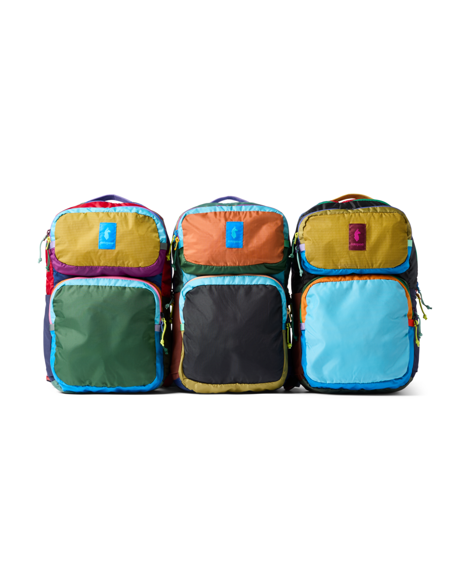 Three colorful backpacks with mixed fabric panels in bright colors, front view on white background