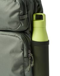 Olive green backpack with yellow water bottle in side pocket, detail view