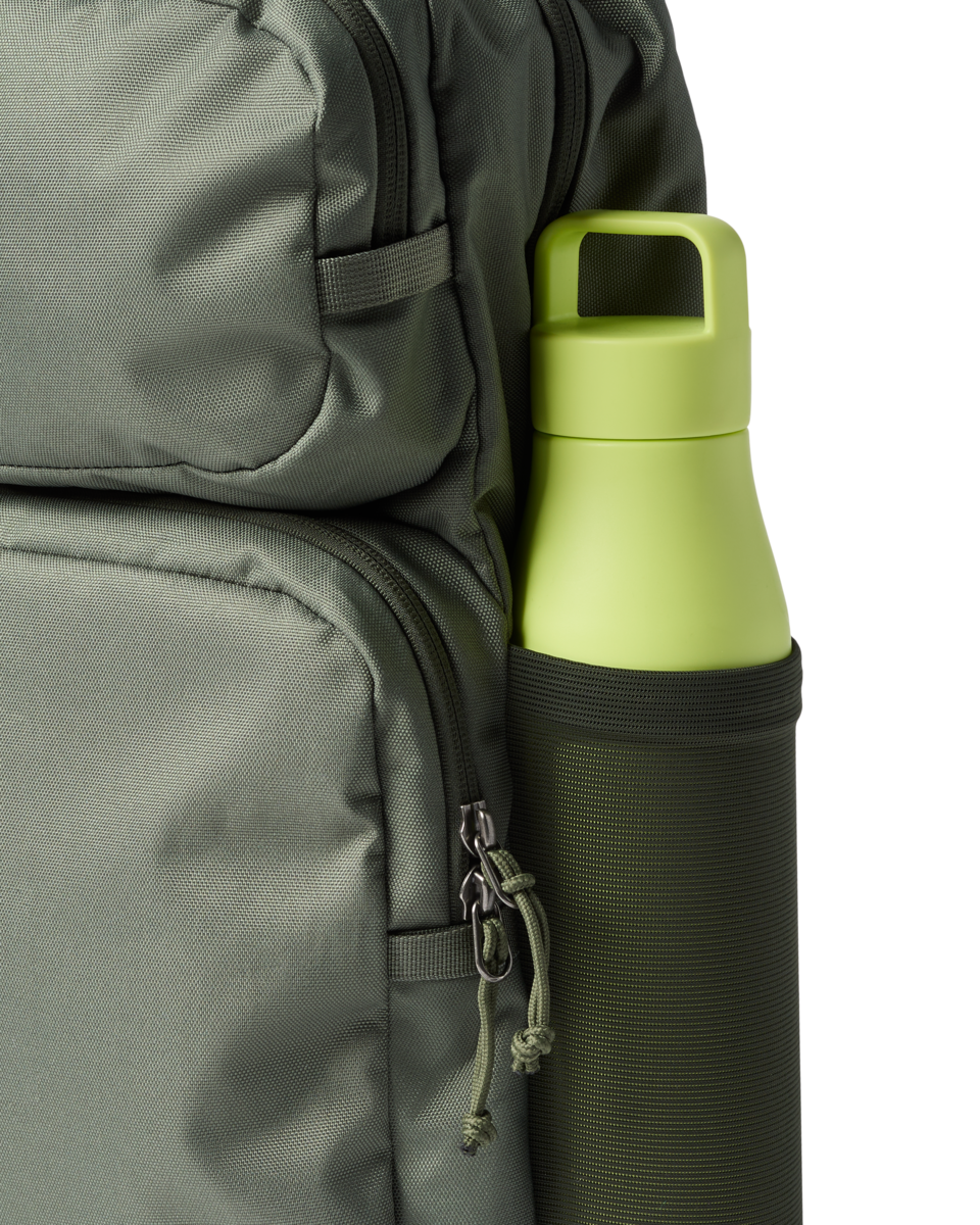 Olive green backpack with yellow water bottle in side pocket, detail view