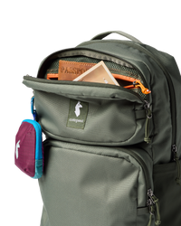 Olive green backpack with open front compartment showing passport and organizational pockets