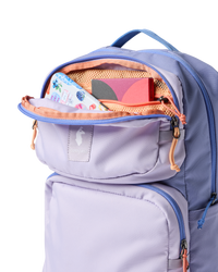 Light purple backpack with open main compartment showing orange interior and organized contents