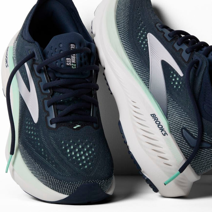 Navy blue running shoes with mesh upper, white swoosh logo, and light green accents