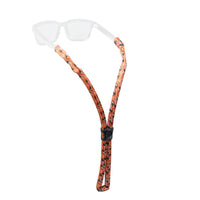 Floating eyewear retainer strap with orange patterned design and adjustment slider