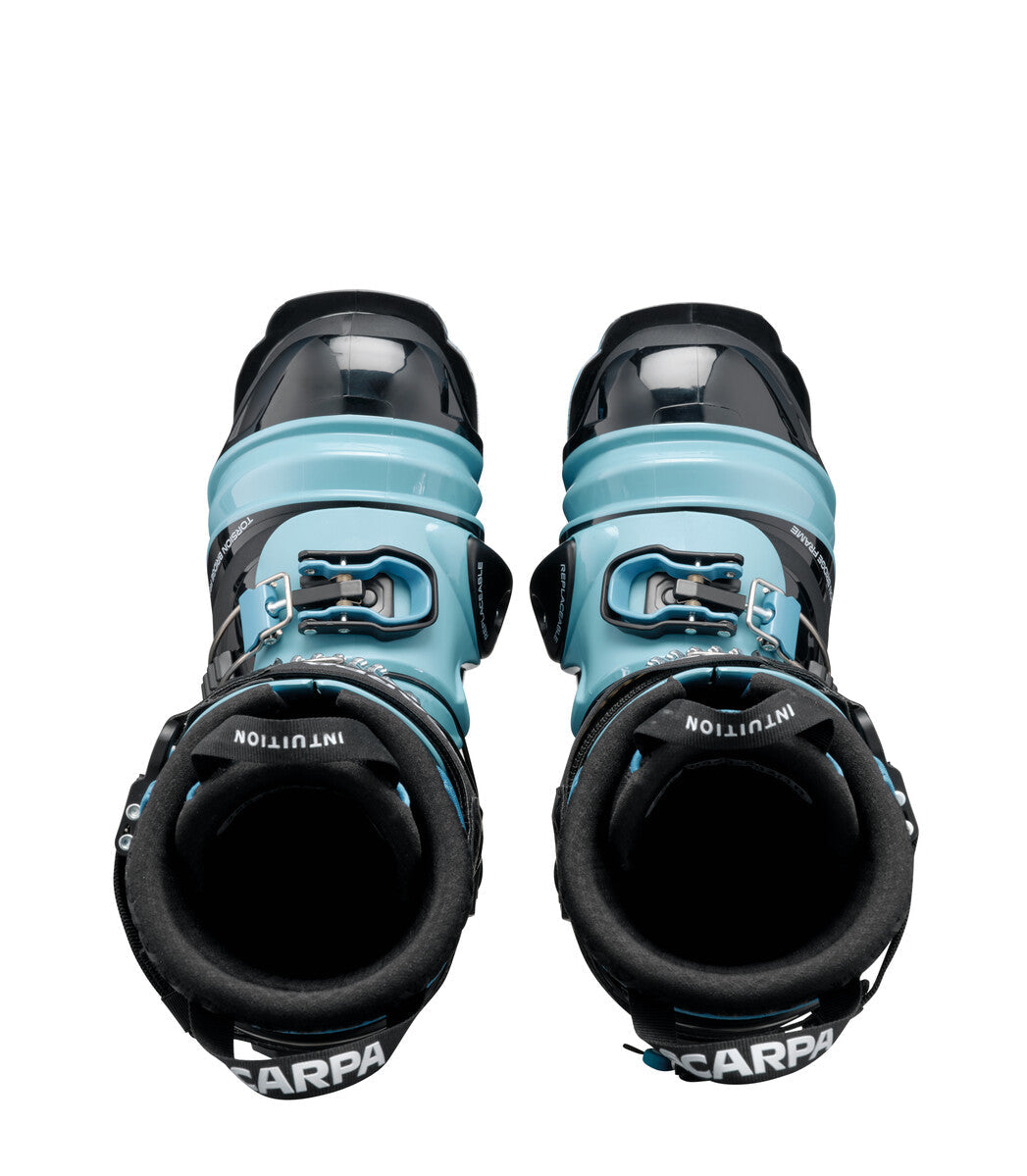 Pair of alpine ski touring boots with light blue cuff and black shell, top-down view