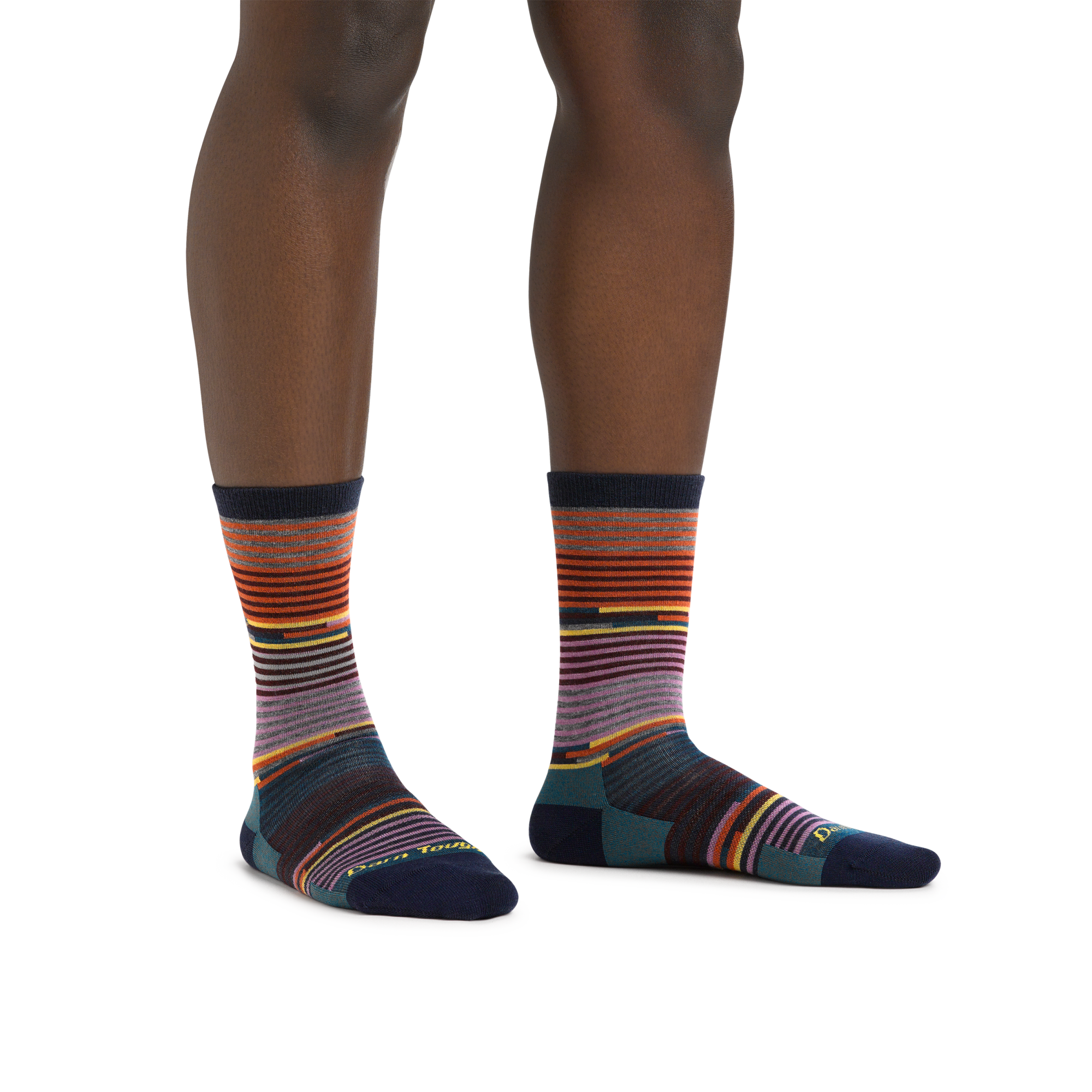 Crew-length striped socks with multicolor horizontal stripes on model's feet, front view
