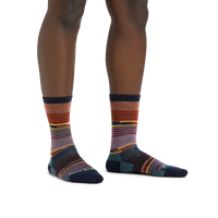 Crew-length striped socks with multicolor horizontal stripes on model's feet, front view