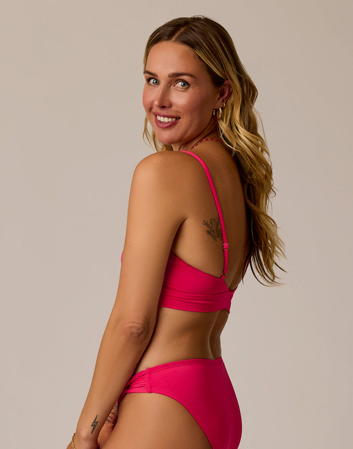 Women's pink bikini top with adjustable straps, shown from the back on a model