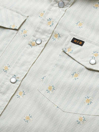Close-up detail of western snap shirt with floral grid pattern, chest pockets, and silver snaps