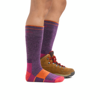Tall knee-high hiking socks in purple with colorblock pink and orange accents, shown with hiking boot