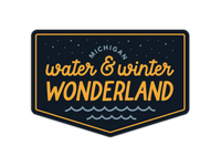 Shield-shaped sticker with navy background, orange text reading water and winter wonderland with stars