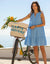Light blue sleeveless tiered dress with V-neck worn by woman with bicycle