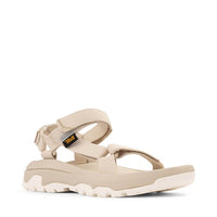 Light colored sport sandal with adjustable straps and rugged sole, side view