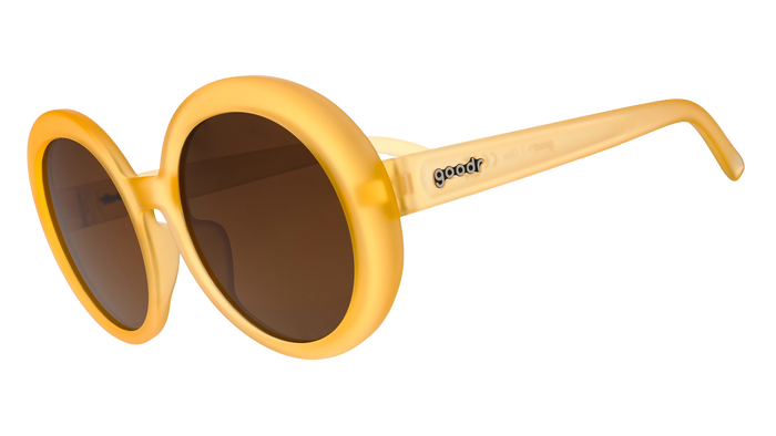 Round oversized sunglasses with golden yellow frames and brown gradient lenses, side angle view