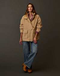 Women's oversized boucle coat in warm tan, front view, worn with wide-leg jeans