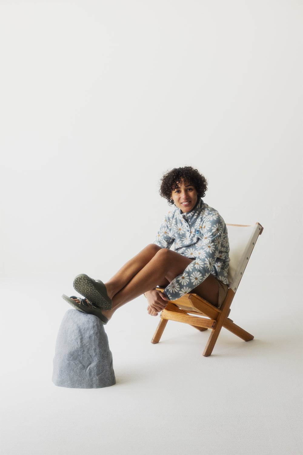 Light blue button-up shirt with white daisy print worn by seated woman