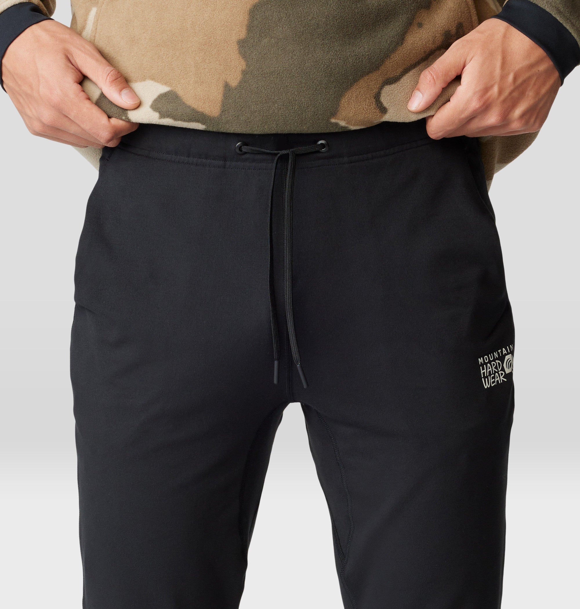 Black drawstring jogger pants with brand logo, close-up front view on model