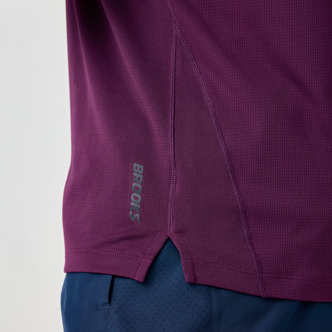 Deep purple athletic short sleeve shirt with side seam detail and brand logo