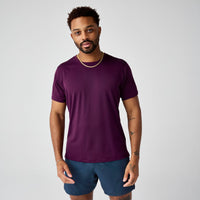 Man wearing deep purple short sleeve athletic t-shirt with blue shorts