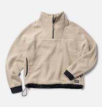Cream grid-fleece half-zip pullover with black cuffs, hem trim, and quarter-zip collar, flat lay view