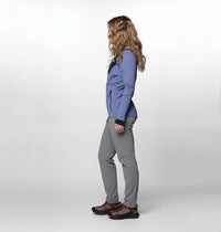 Side view of women's slim-fit gray hiking pants on model with athletic shoes