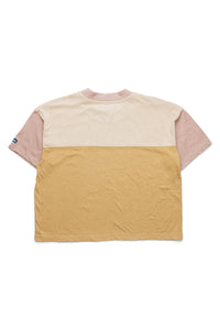 Color-blocked short sleeve t-shirt with pink sleeves, cream chest, and yellow bottom section