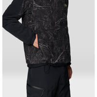 Close-up side view of men's fleece hoodie with tree-branch camo print and black sleeves, hand in pocket