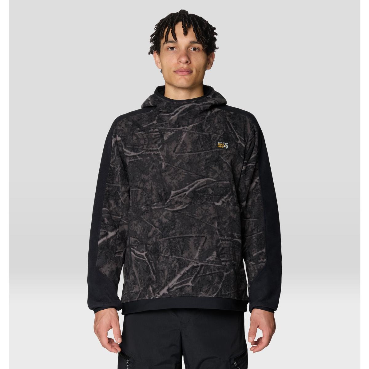 Men's pullover fleece hoodie with tree-branch camo print front and solid black sleeves, front view
