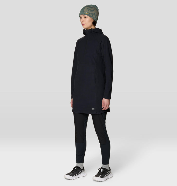 Women's long hooded fleece dress with kangaroo pocket, worn over black leggings, front-angled view