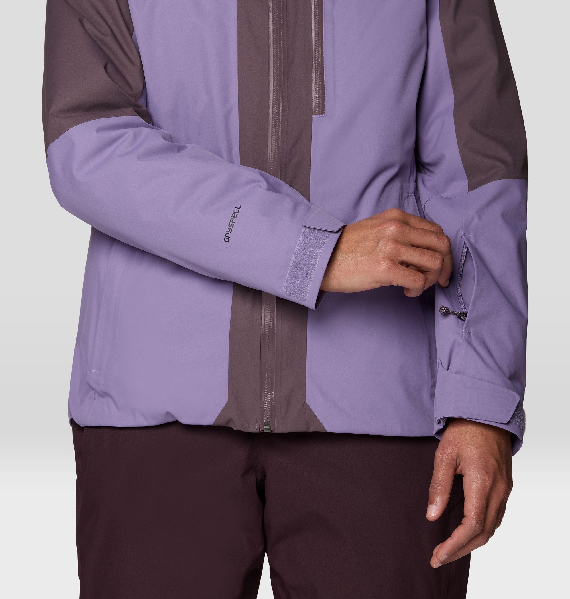 Close-up detail of women's ski jacket sleeve with velcro cuff and Dryspell branding, two-tone purple colorblock