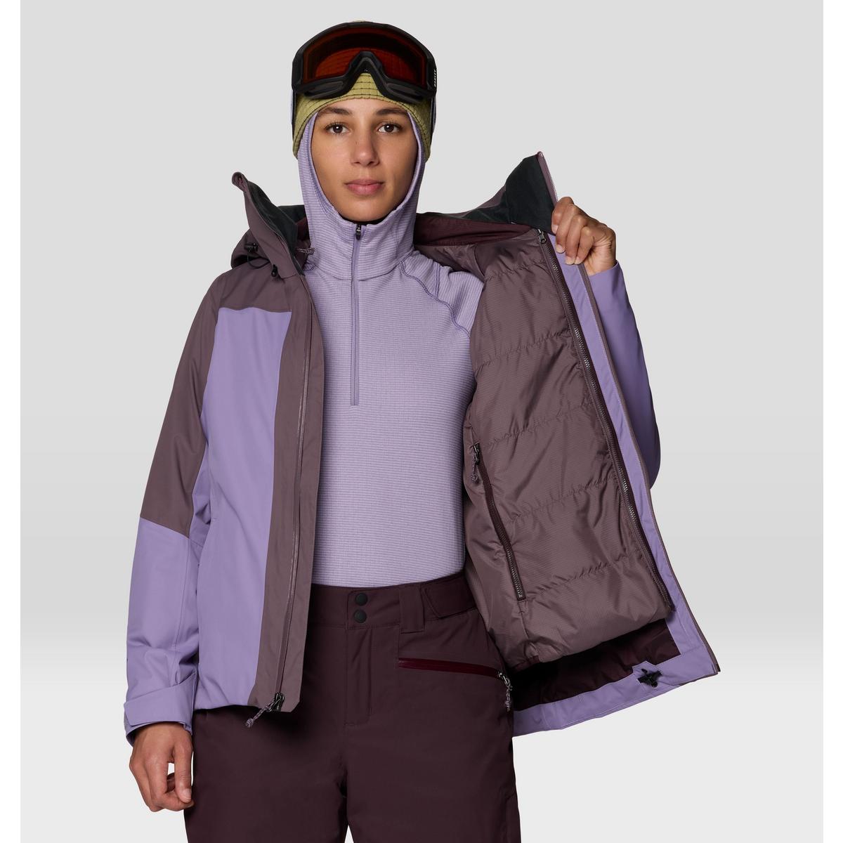 Women's ski jacket open to show insulated lining, worn with base layer, goggles, and hood