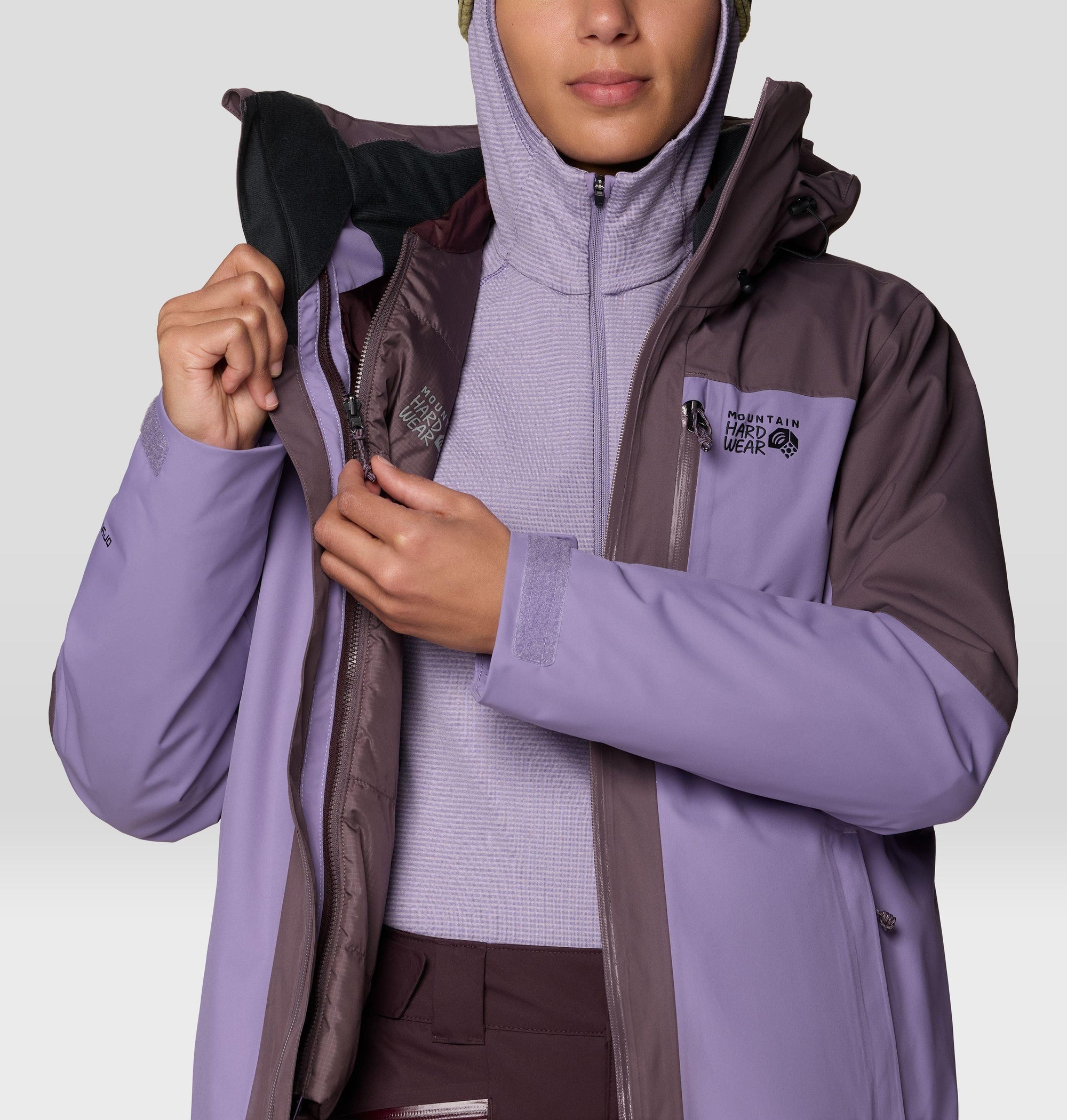 Women's insulated ski jacket detail shot showing open zipper, hood, and layering system