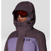 Women's ski jacket close-up with adjustable hood, red ski goggles, and two-tone purple colorblock design
