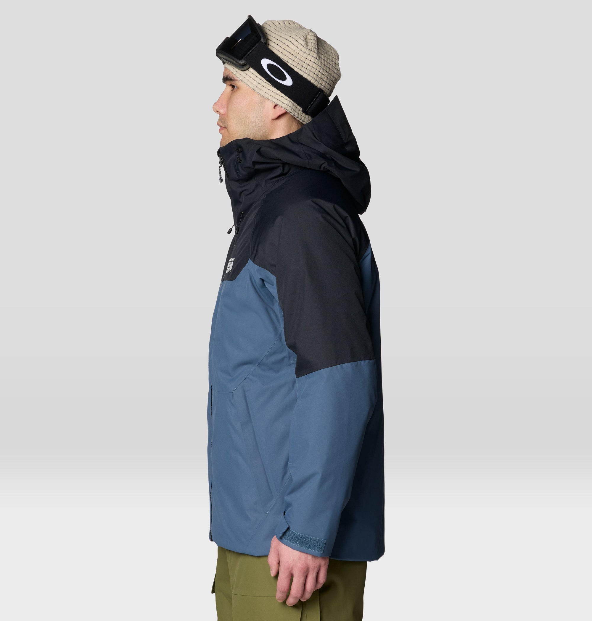 Men's ski jacket with blue and black colorblock design, hooded, side view on model