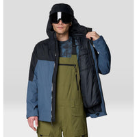 Men's insulated ski jacket open to show interior lining, colorblock blue and black design, on model with goggles