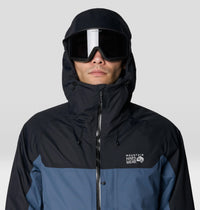 Men's hooded ski jacket with colorblock design, worn with Oakley goggles, close-up front view