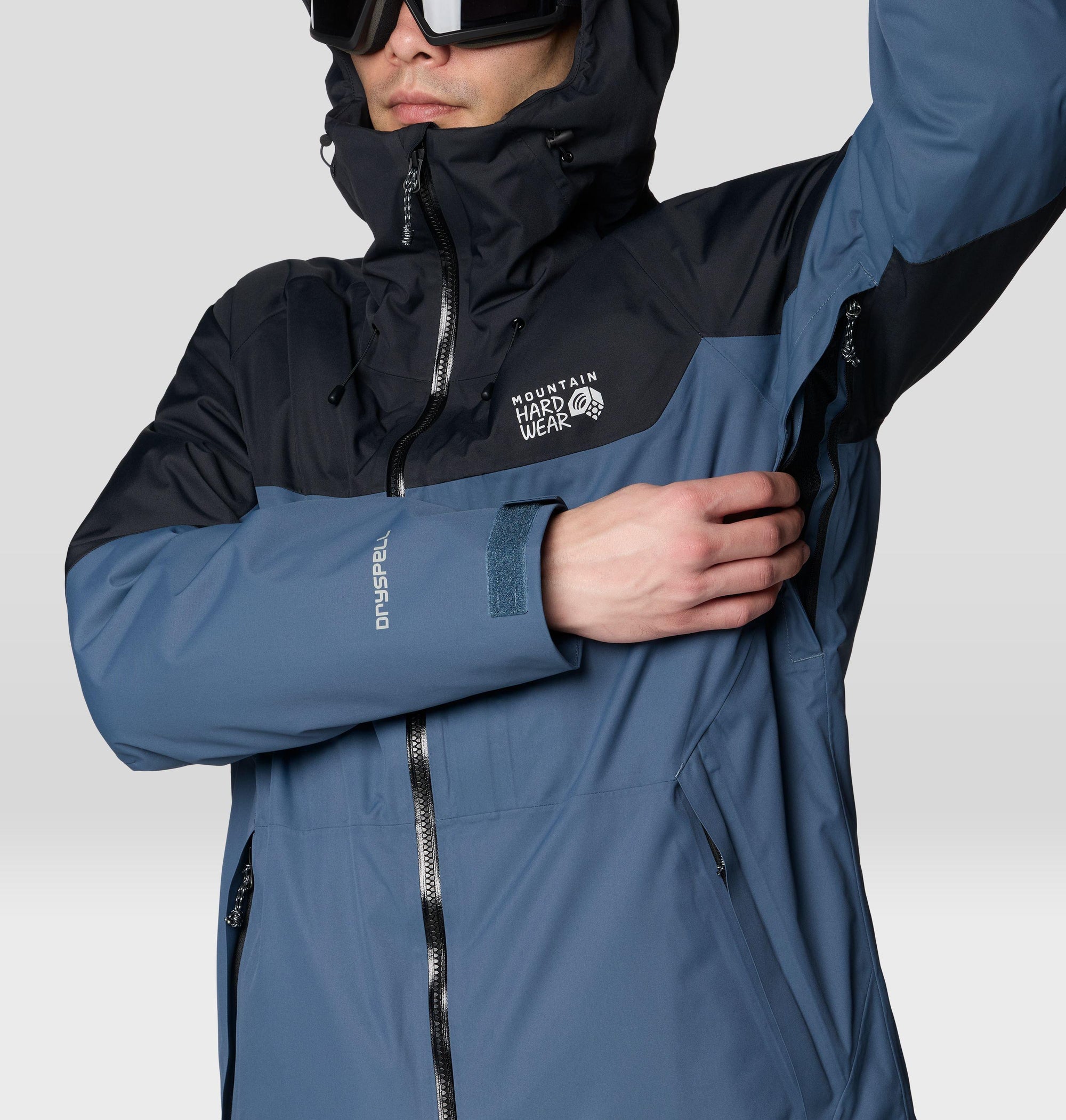 Men's ski jacket with two-tone blue and black colorblock design, hood up, detail close-up view